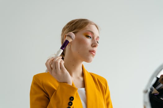 woman applying makeup in front of a mirror